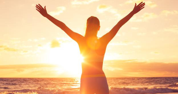 Woman looking at sunset and sea
